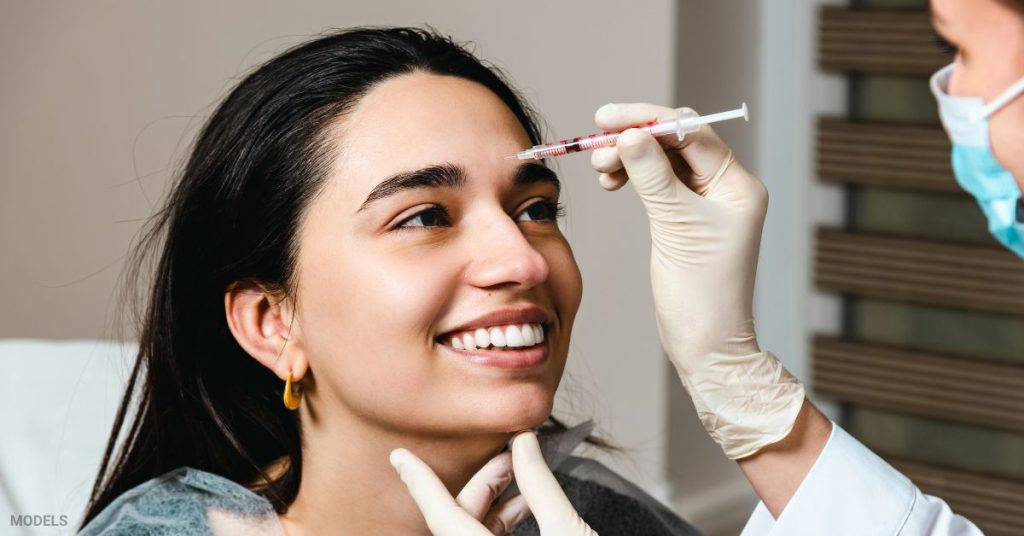 Woman receiving a BOTOX® injection from a provider. (MODELS)